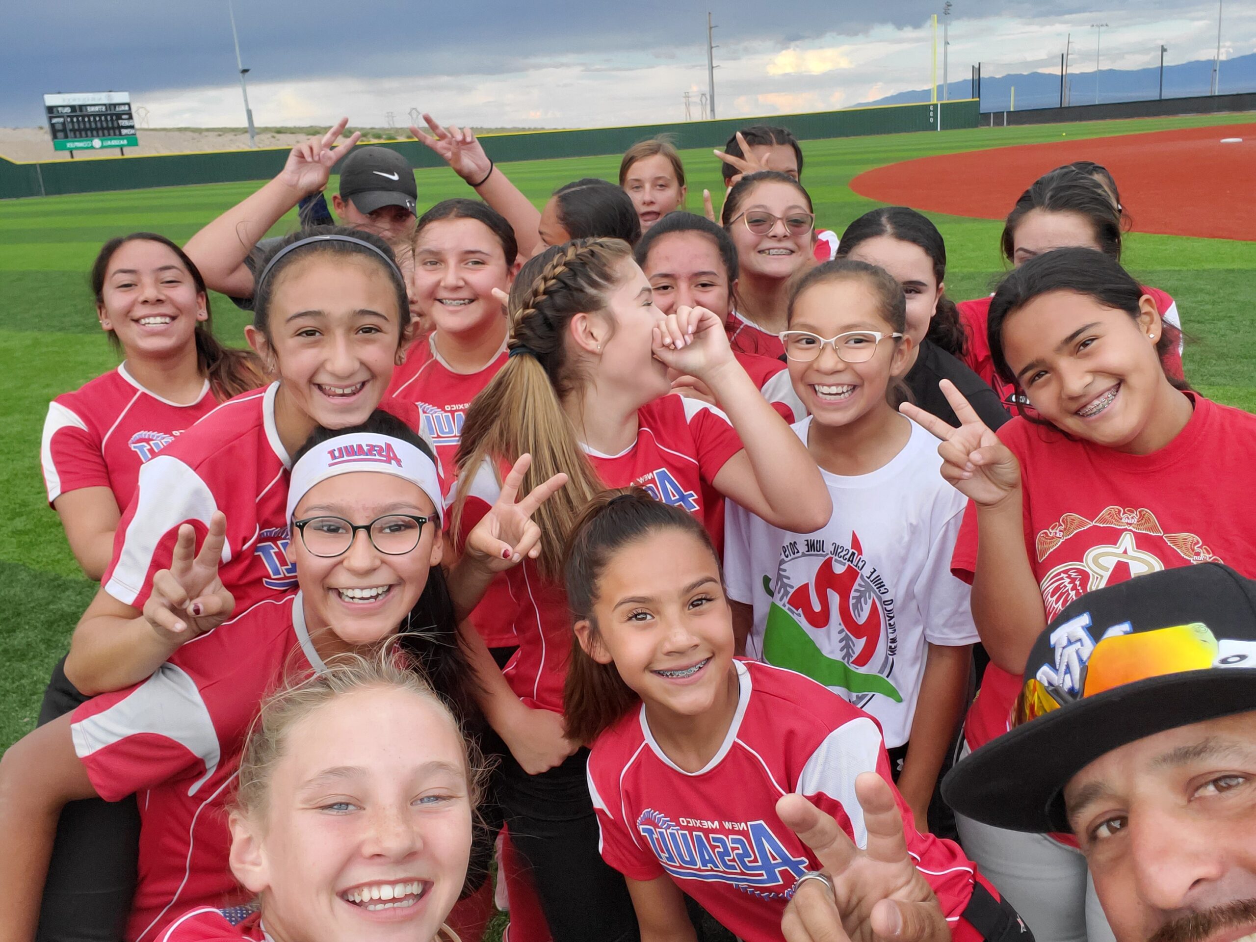 Assault Fastpitch players celebrating together as part of A Positive Trajectory Foundation